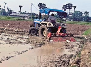 बांका में ट्रैक्टर से खेत की जुताई करता किसान.