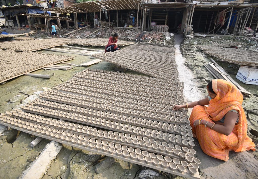 Women puts earthen lamps for drying in the sun ahead of Diwali festival 8 1