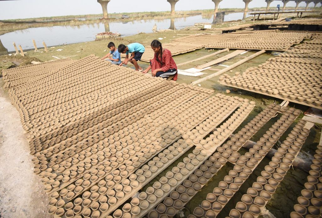 Women Puts Earthen Lamps For Drying In The Sun Ahead Of Diwali Festival 9