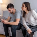 man using smartphone and a girl looking at it