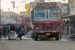 आग लगी ट्रक में पानी डालते दमकल कर्मी